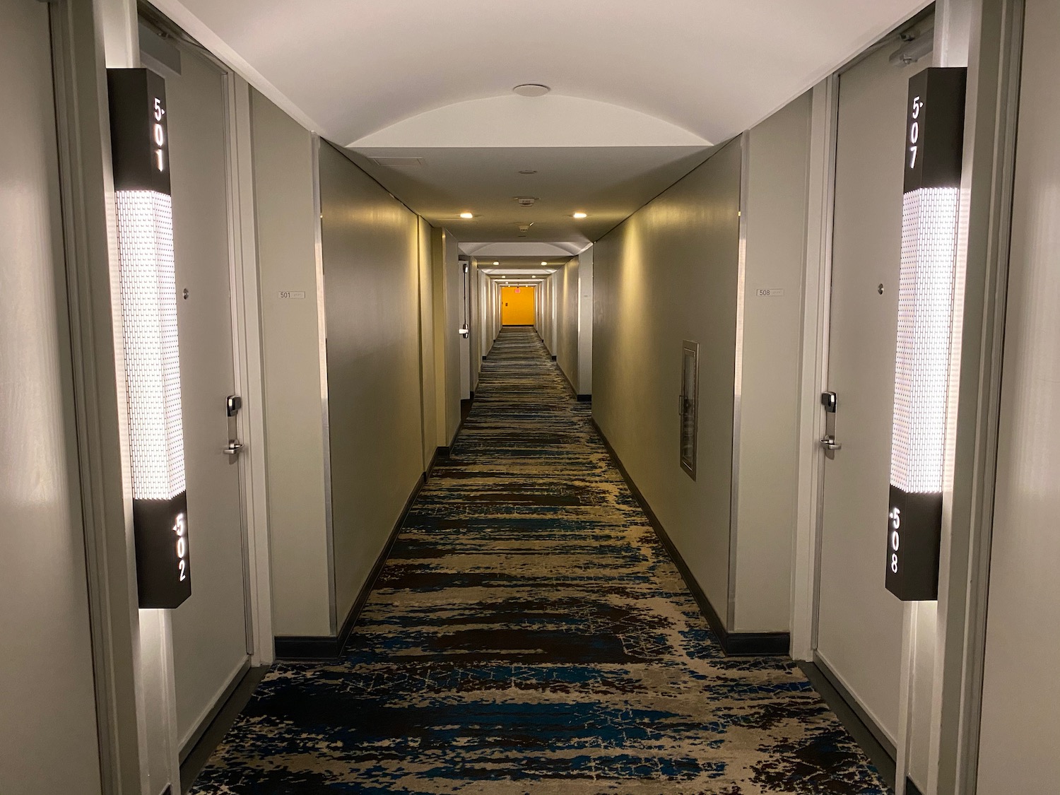 a long hallway with doors and a carpet