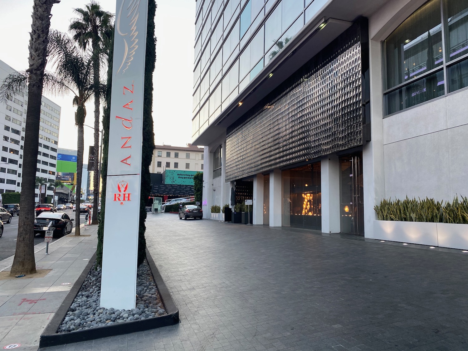 a building with a tall pole and palm trees