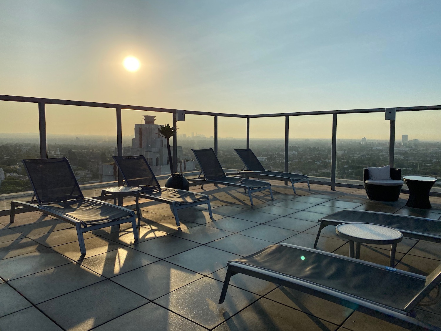 a deck with chairs and a railing on a rooftop