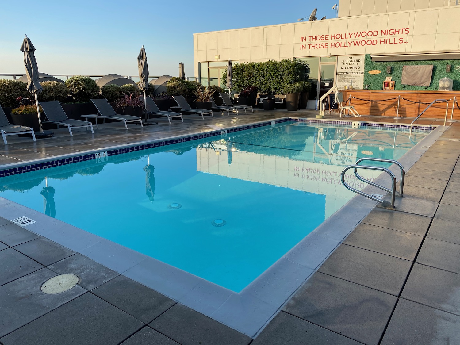 a pool with chairs and a building