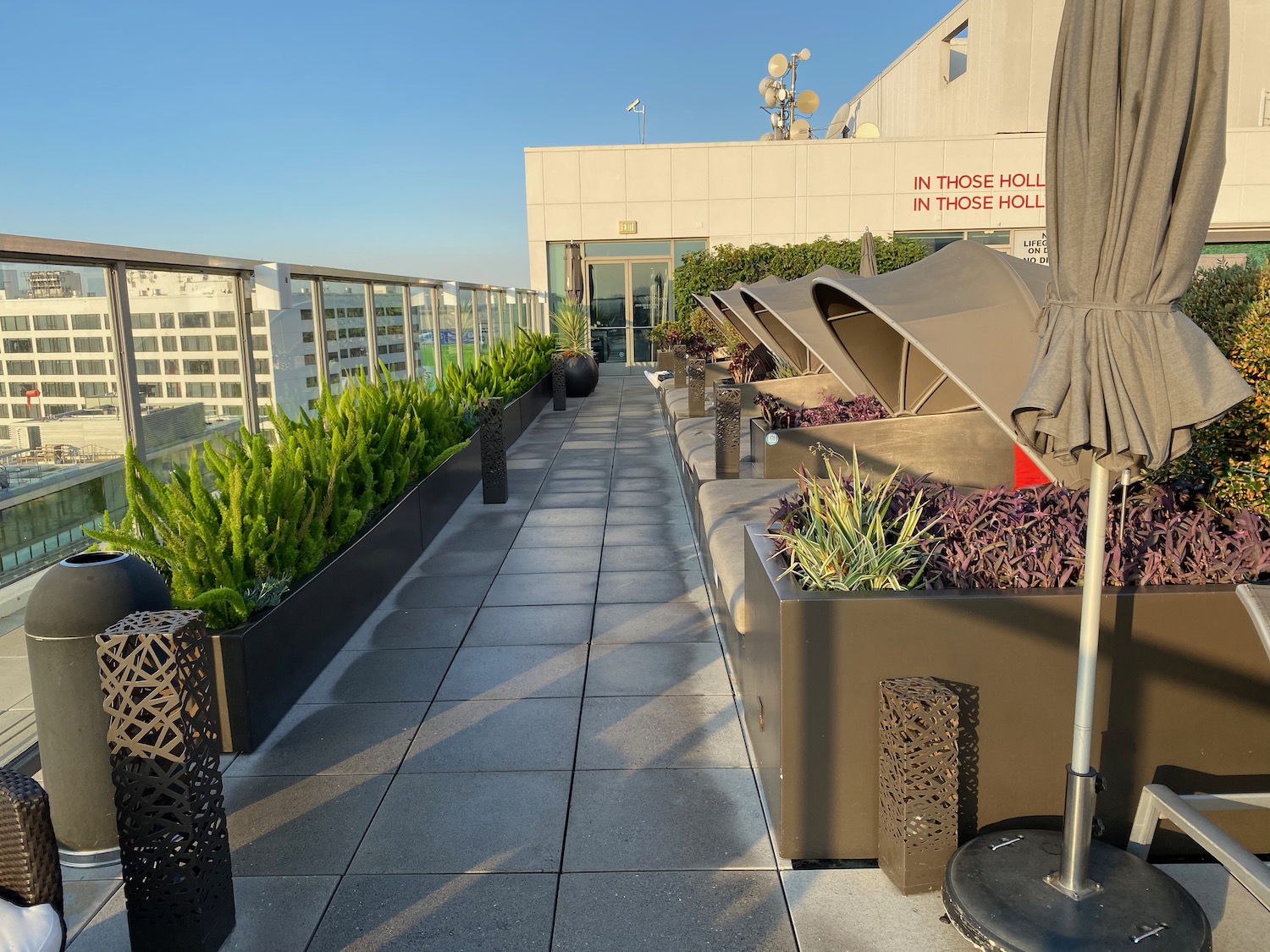 a patio with plants and umbrellas on a rooftop