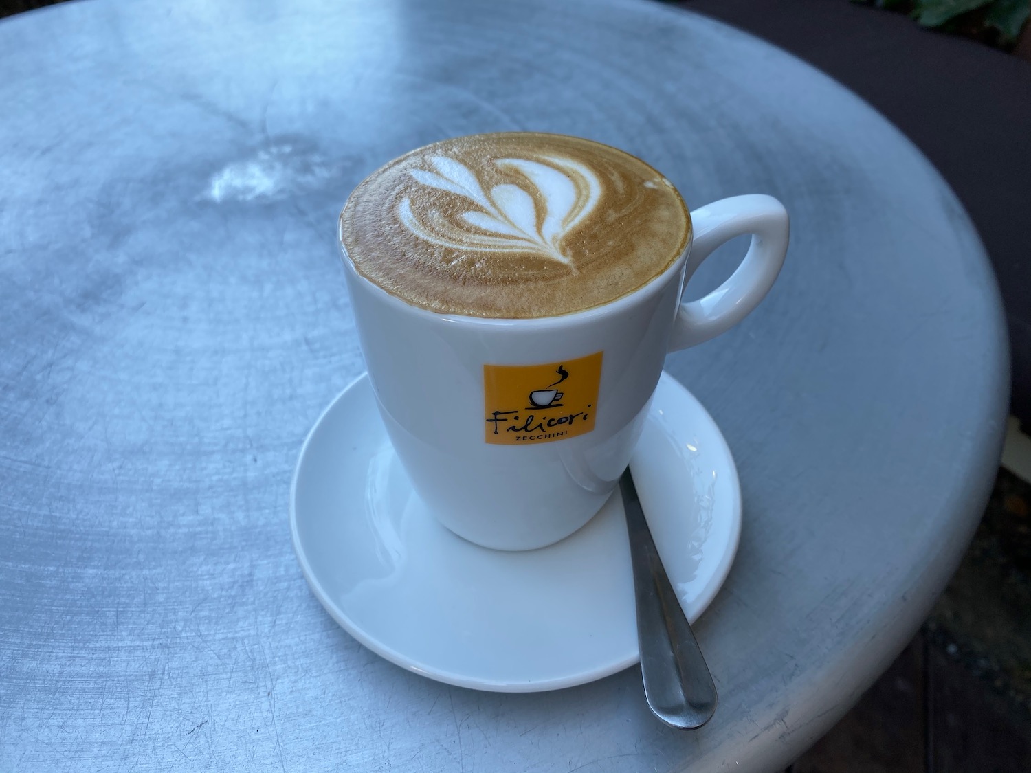 a cup of coffee with a leaf design on top of it