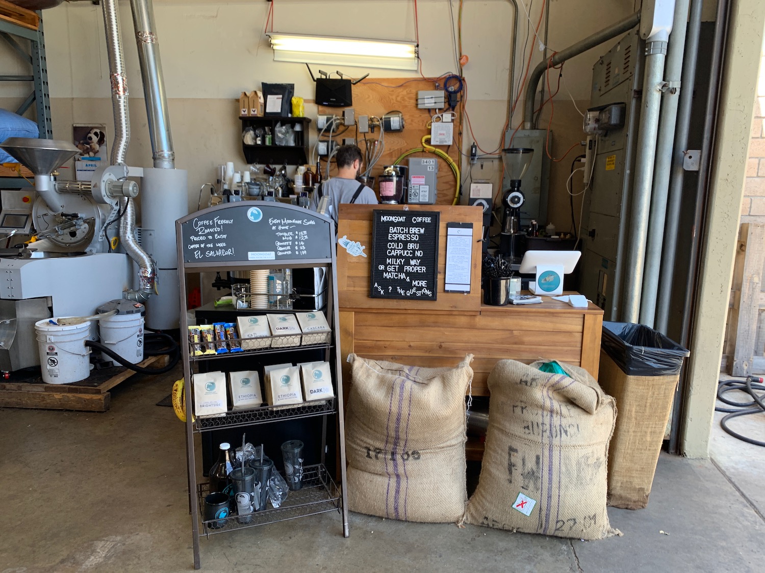 a coffee shop with a man behind a counter