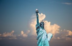 a statue of liberty with clouds in the sky