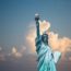 a statue of liberty with clouds in the sky