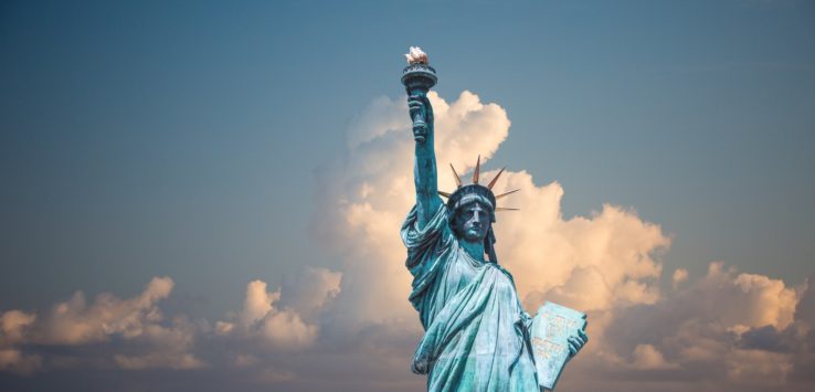 a statue of liberty with clouds in the sky