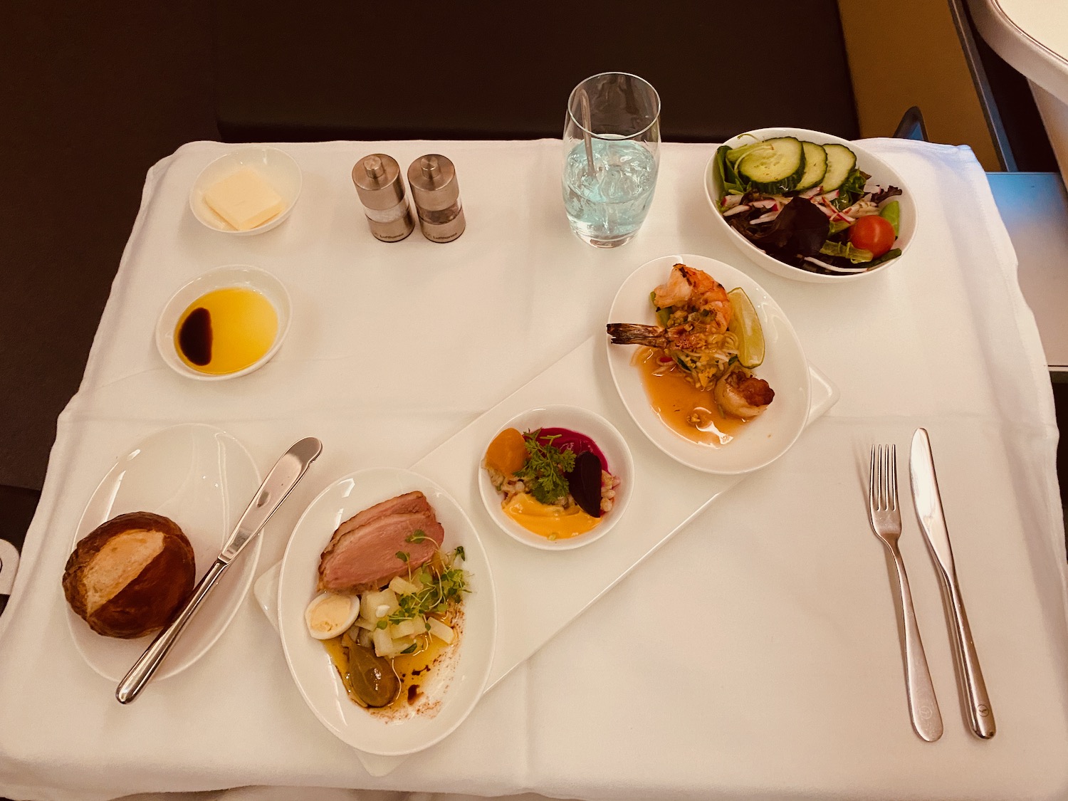 a table with plates of food and a glass of water