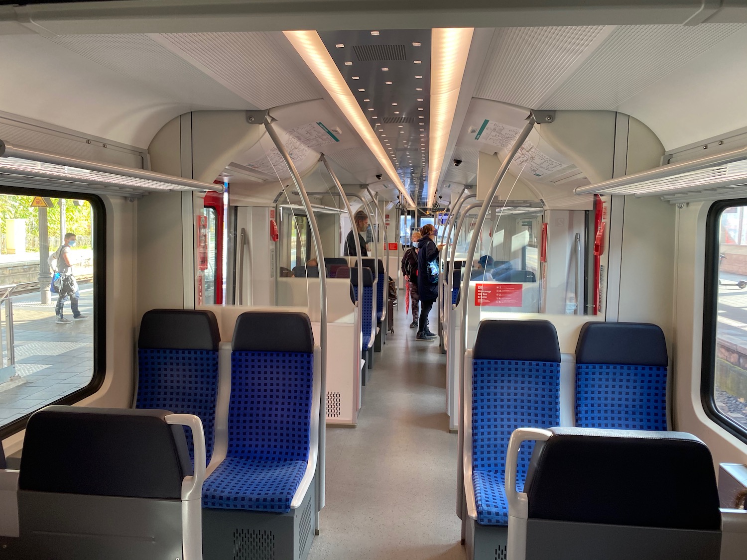 a train with blue seats and people walking