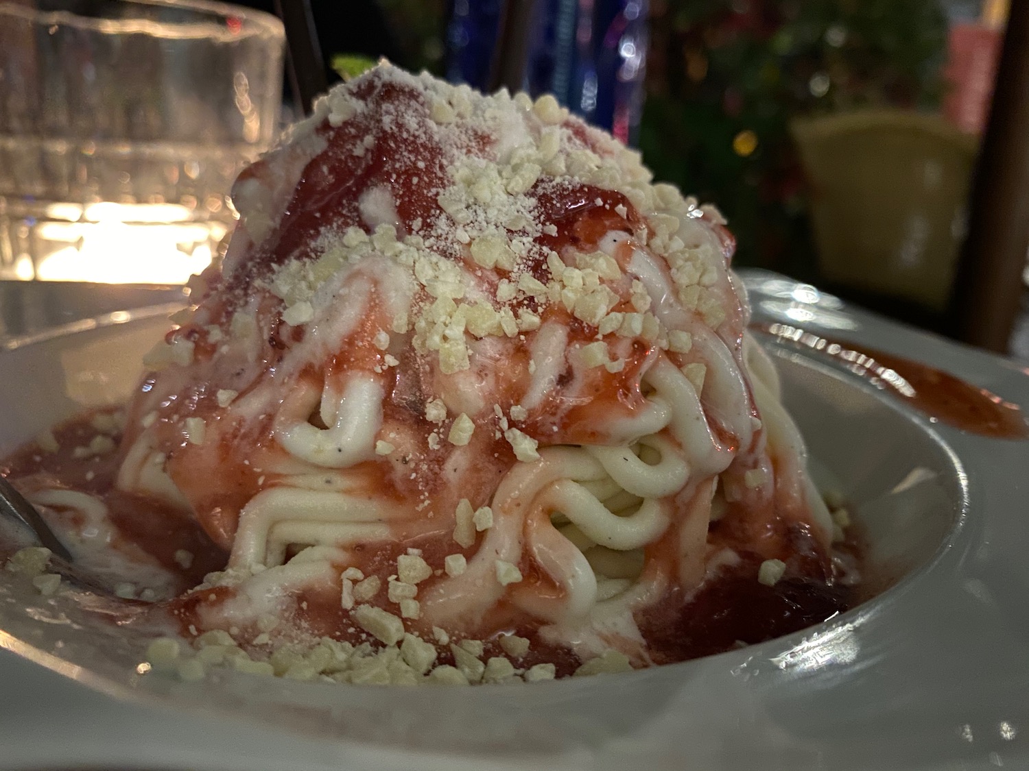 a bowl of spaghetti with sauce and crumbs