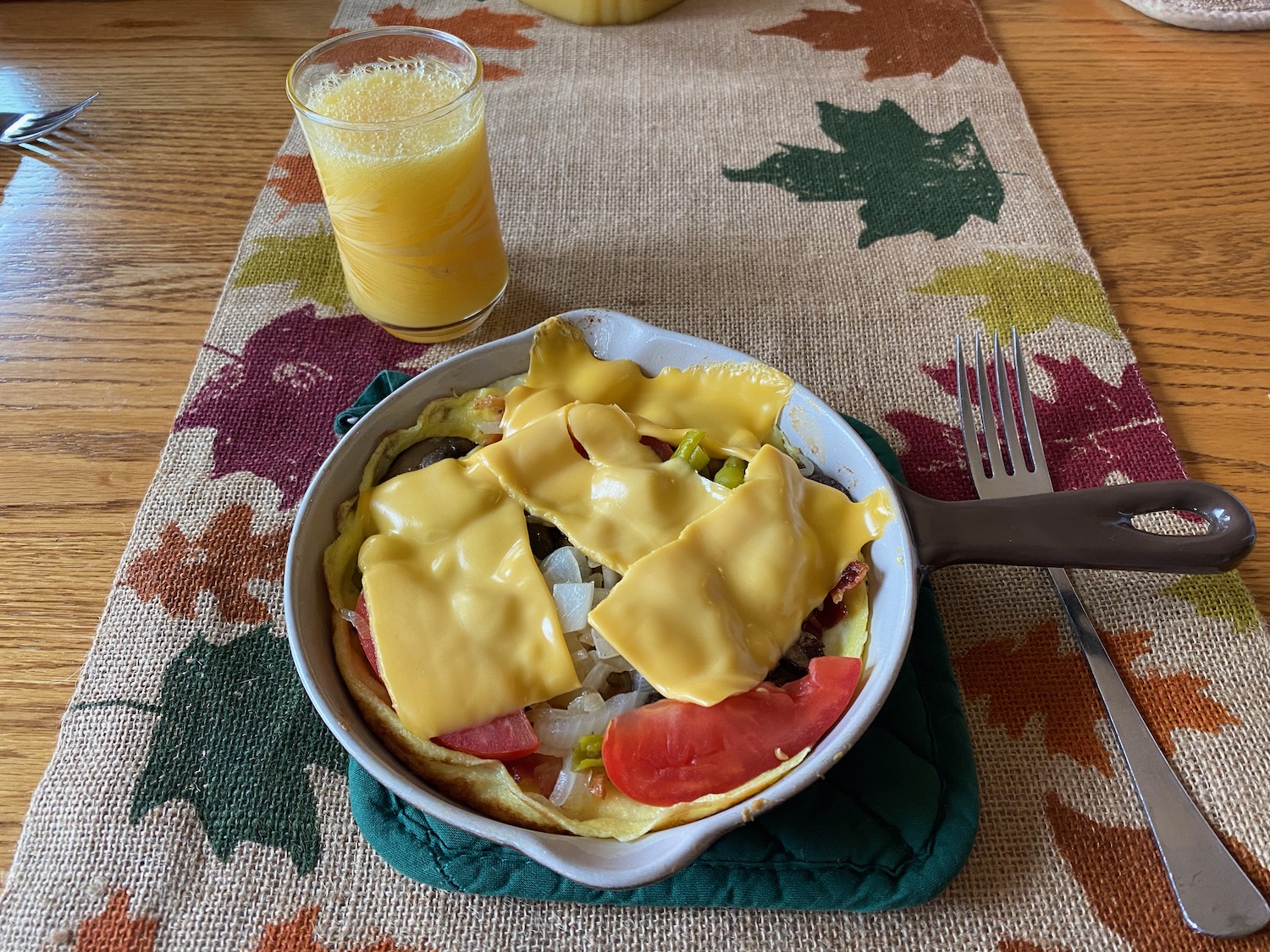 a pan of food with a glass of juice