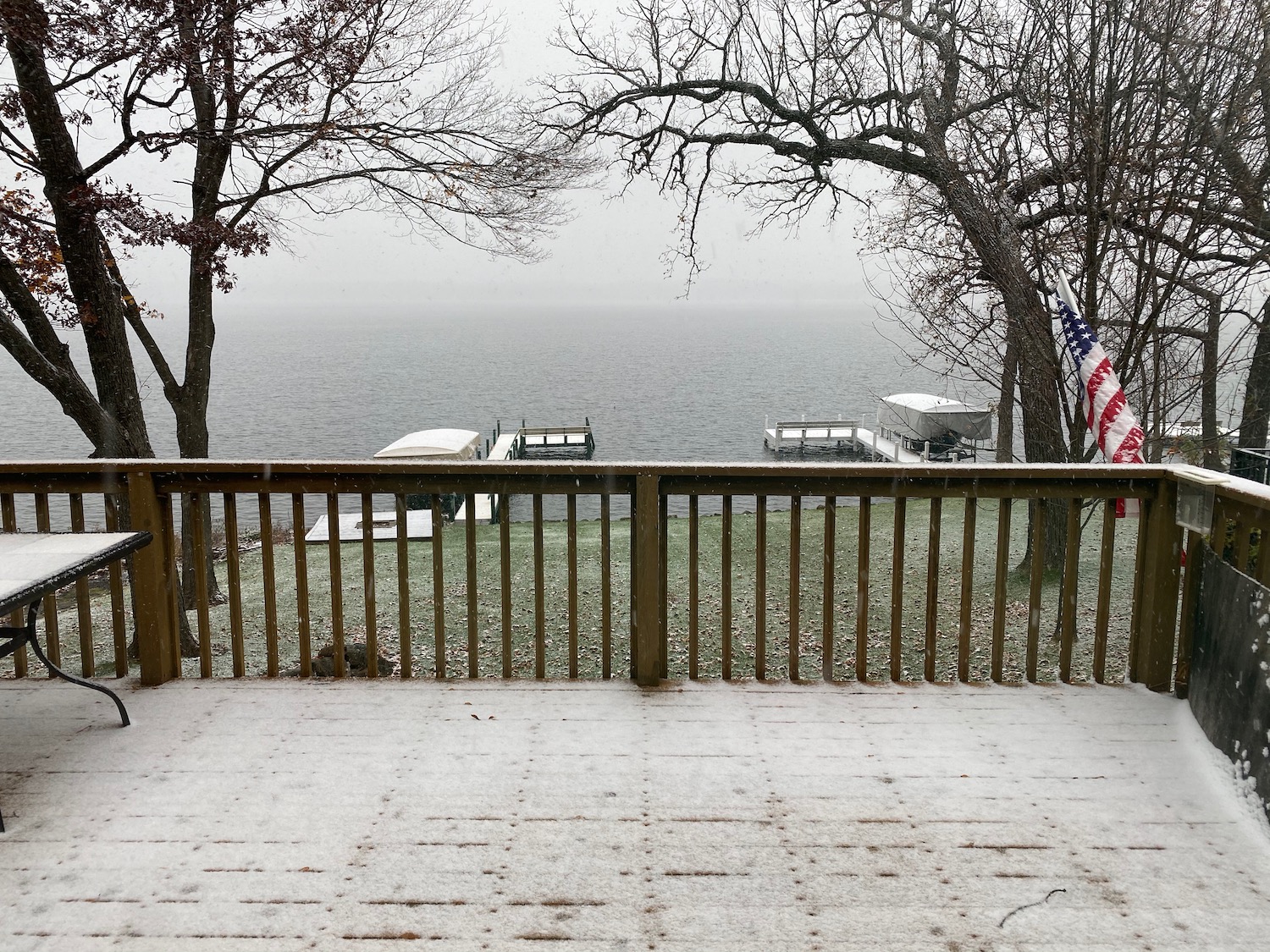 a deck with a view of the water and trees