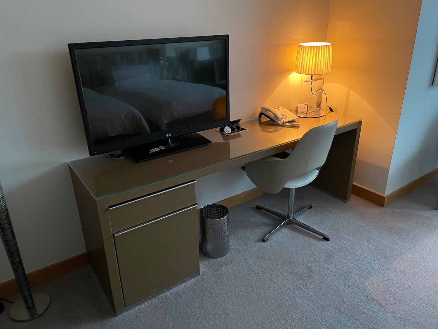 a desk with a television and a lamp