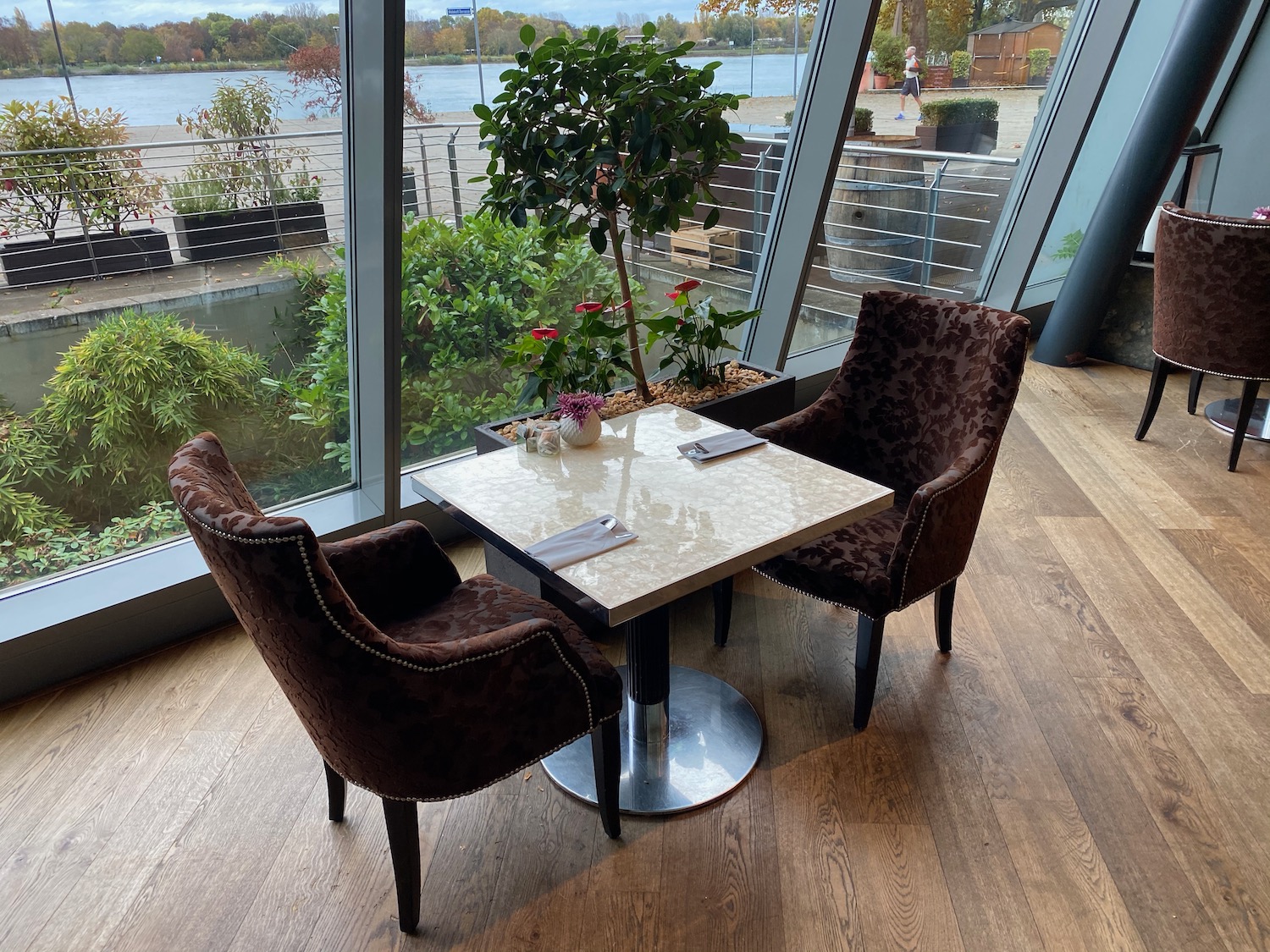 a table and chairs in a room with a view of water and trees