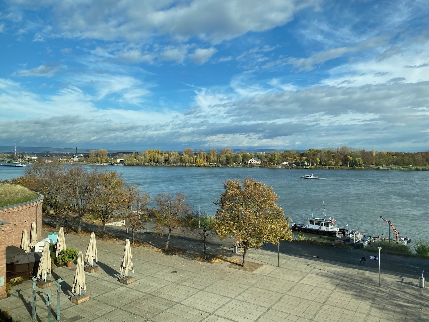 a waterfront with trees and boats on the water