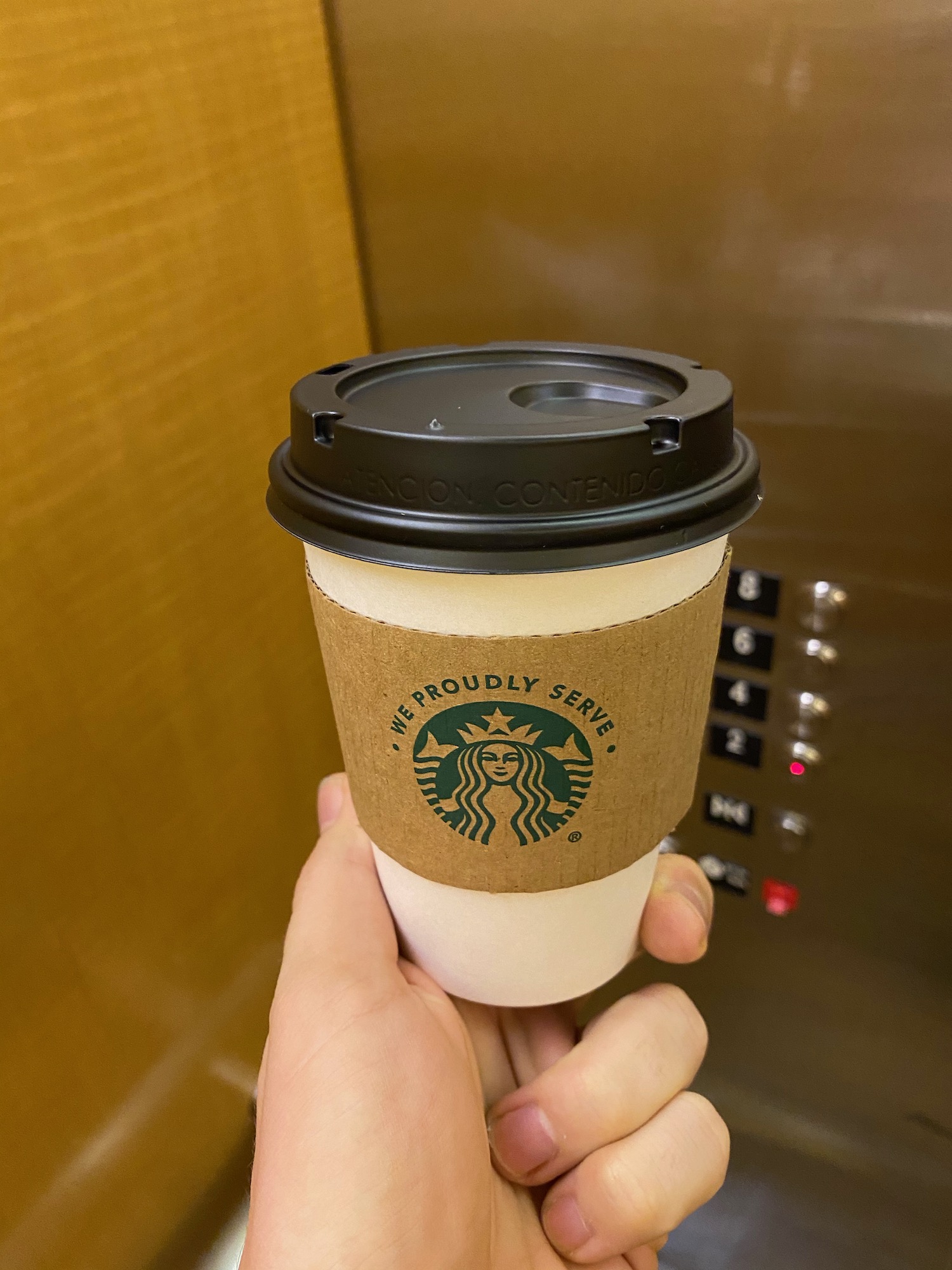 a hand holding a coffee cup