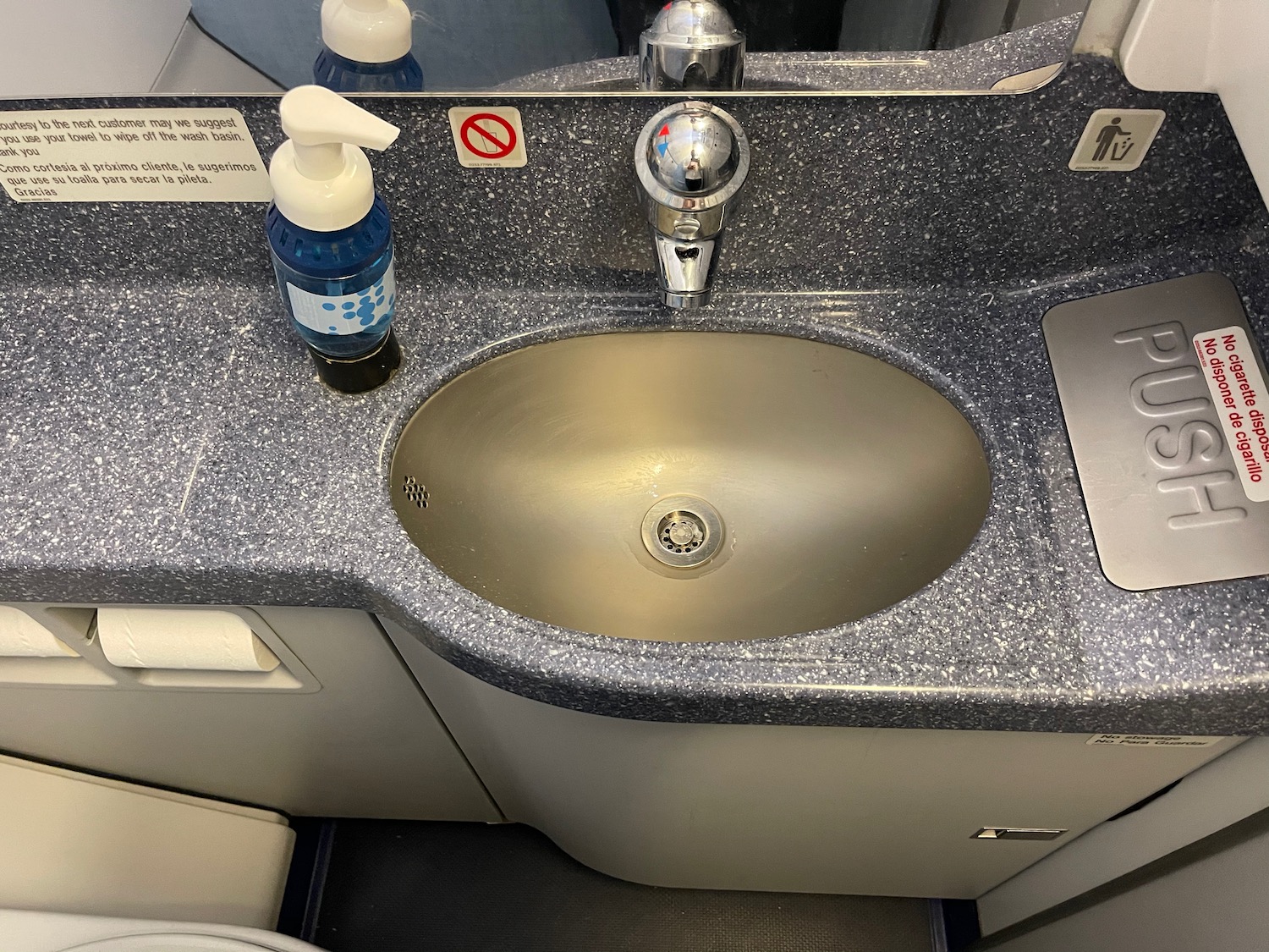 a sink with soap and a bottle of liquid on it