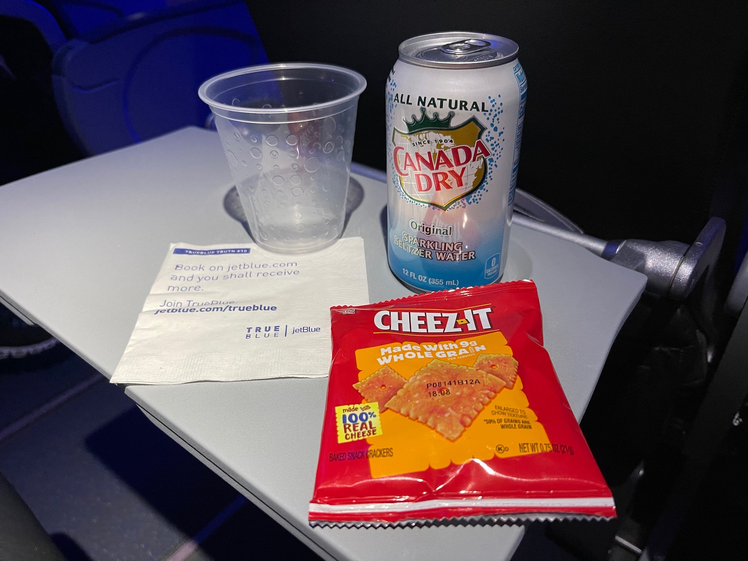 a can of soda and a plastic cup on a table