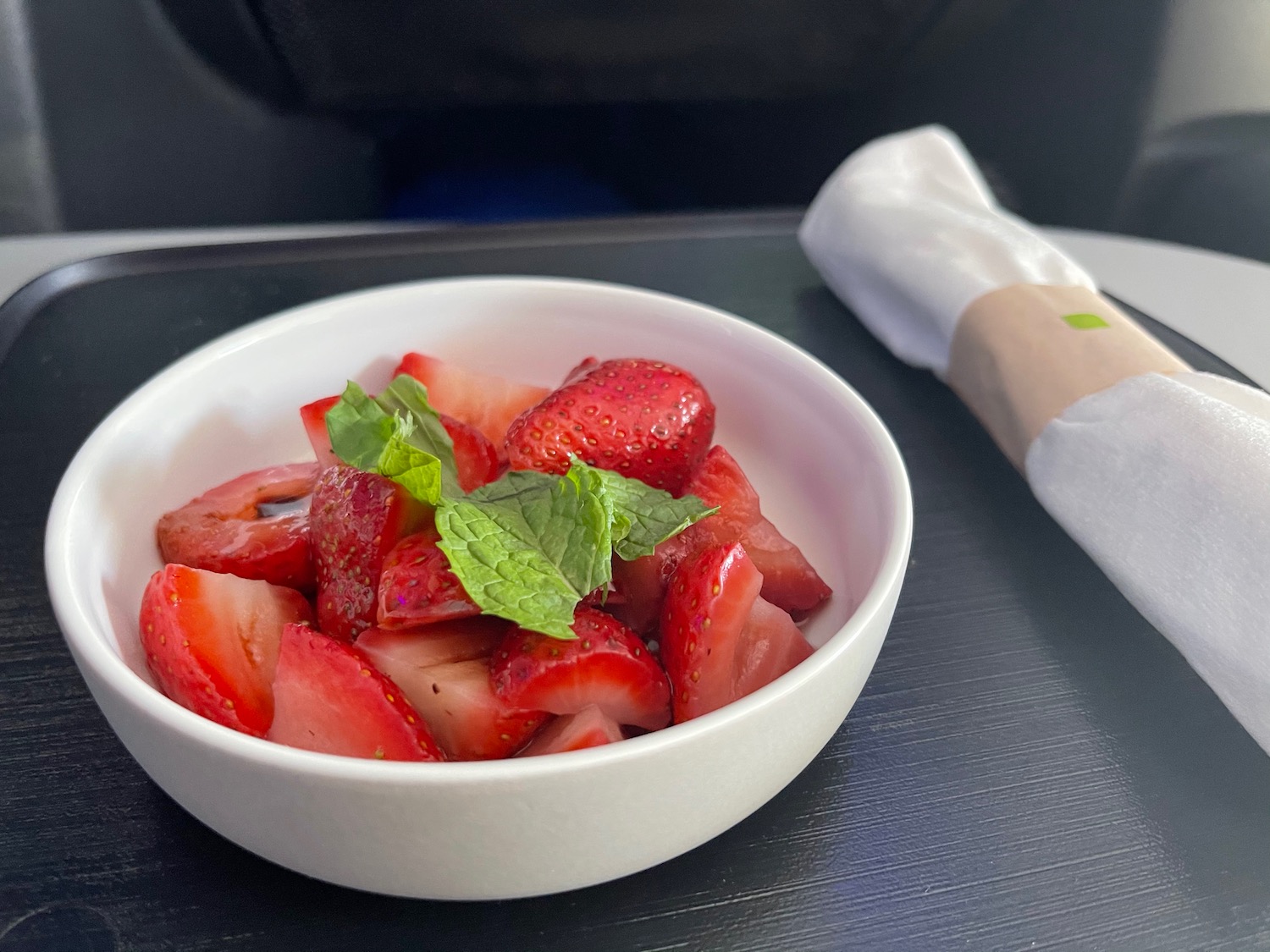 a bowl of strawberries and mint leaves