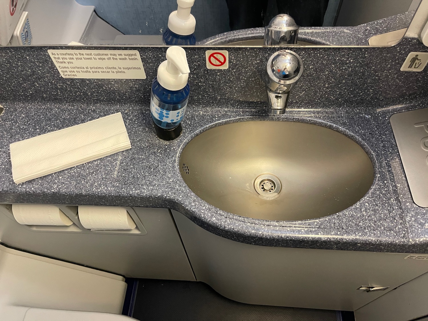 a sink with a soap dispenser and a napkin on the counter