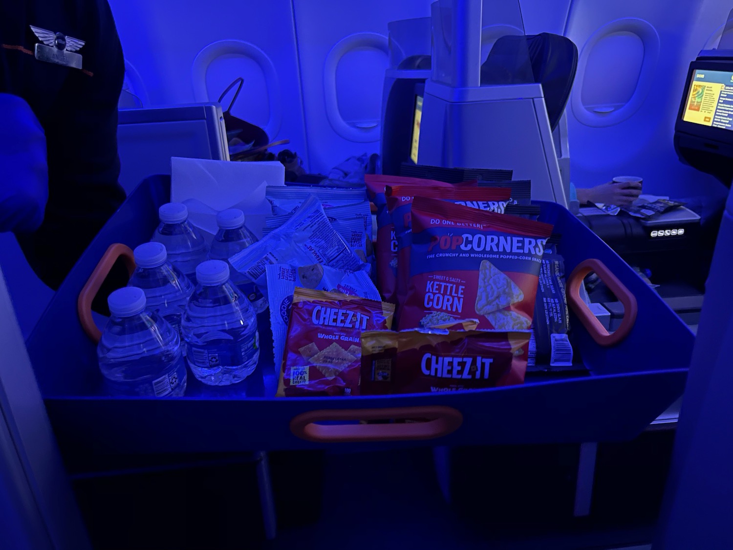 a tray of food and water bottles on an airplane