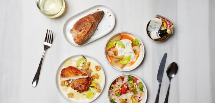 a table with plates of food and a glass of water