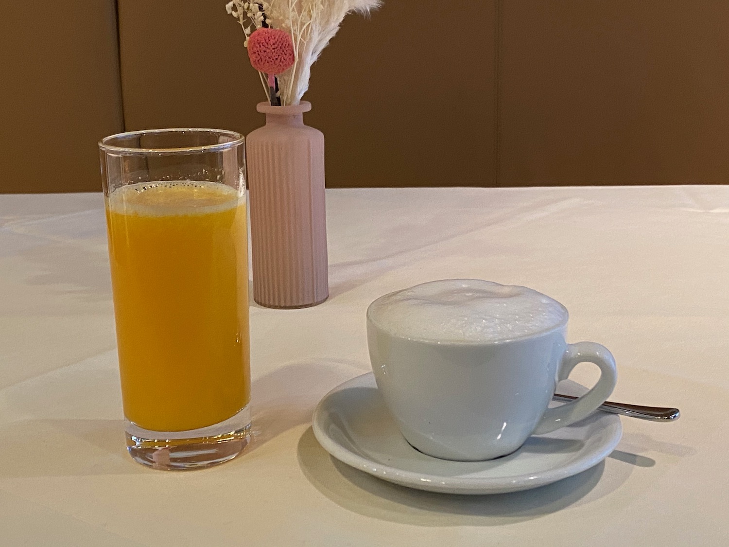 a cup of coffee and a glass of orange juice on a table