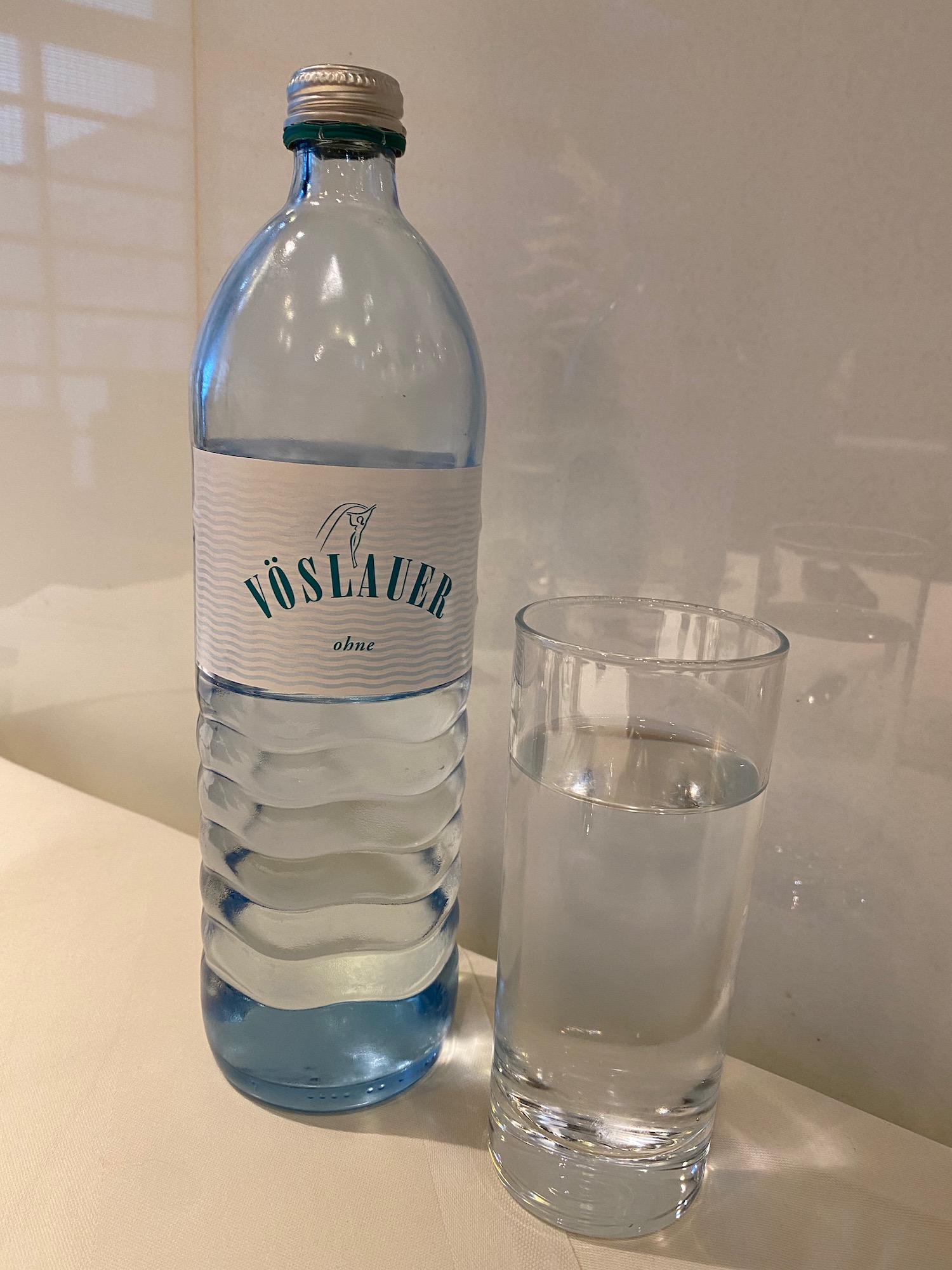 a bottle of water next to a glass of water