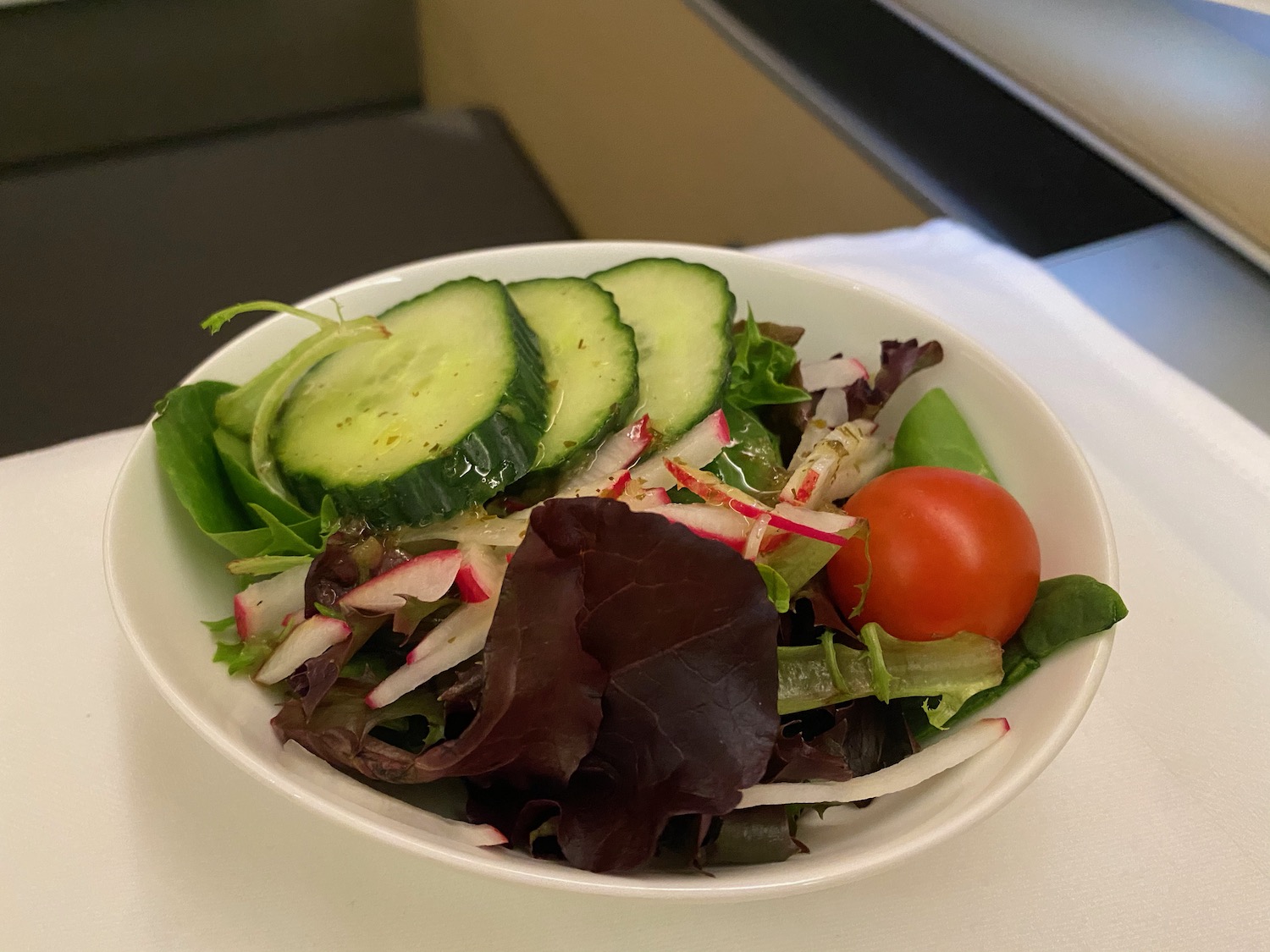a bowl of salad with cucumbers and radishes