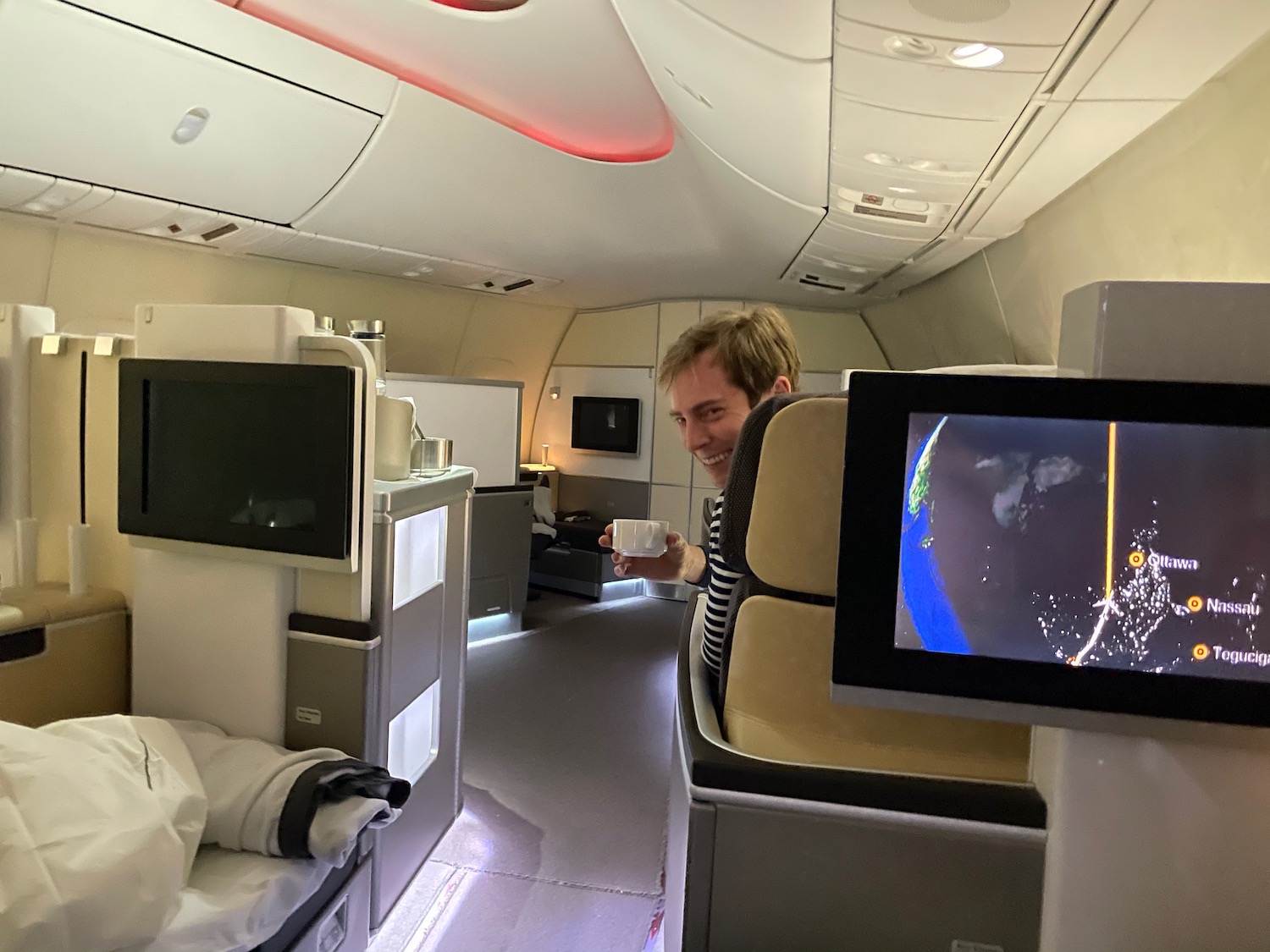 a man sitting in an airplane with a cup of coffee