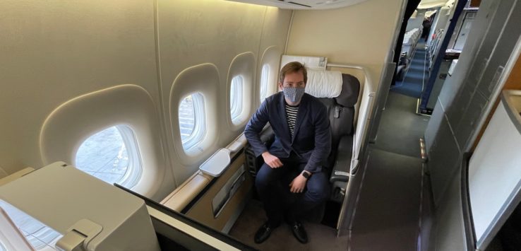 a man wearing a mask sitting in an airplane