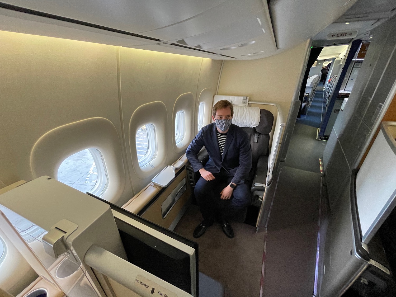 a man wearing a mask sitting in an airplane