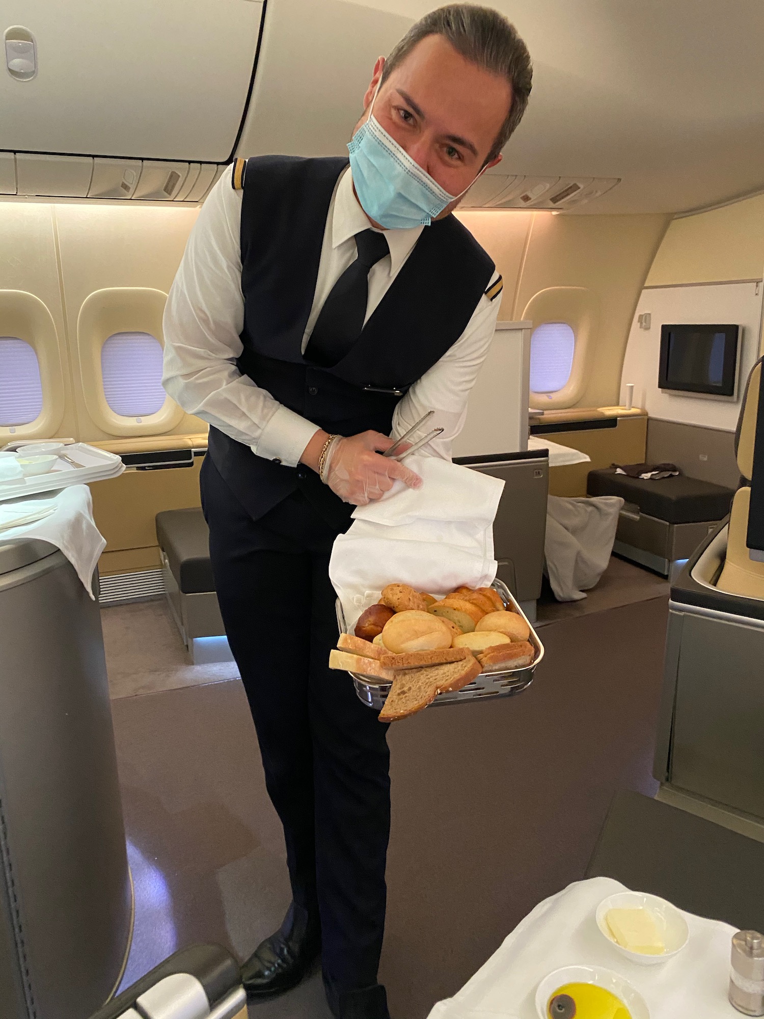 a man wearing a mask and gloves holding a tray of food