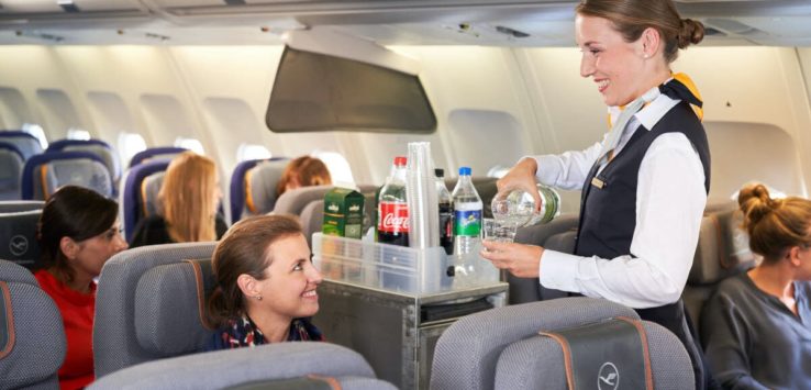 a flight attendant serving drinks on an airplane