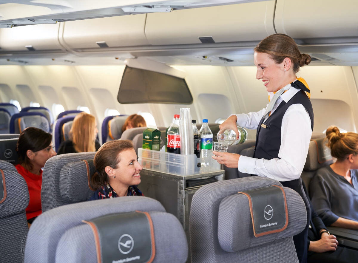 a flight attendant serving drinks on an airplane
