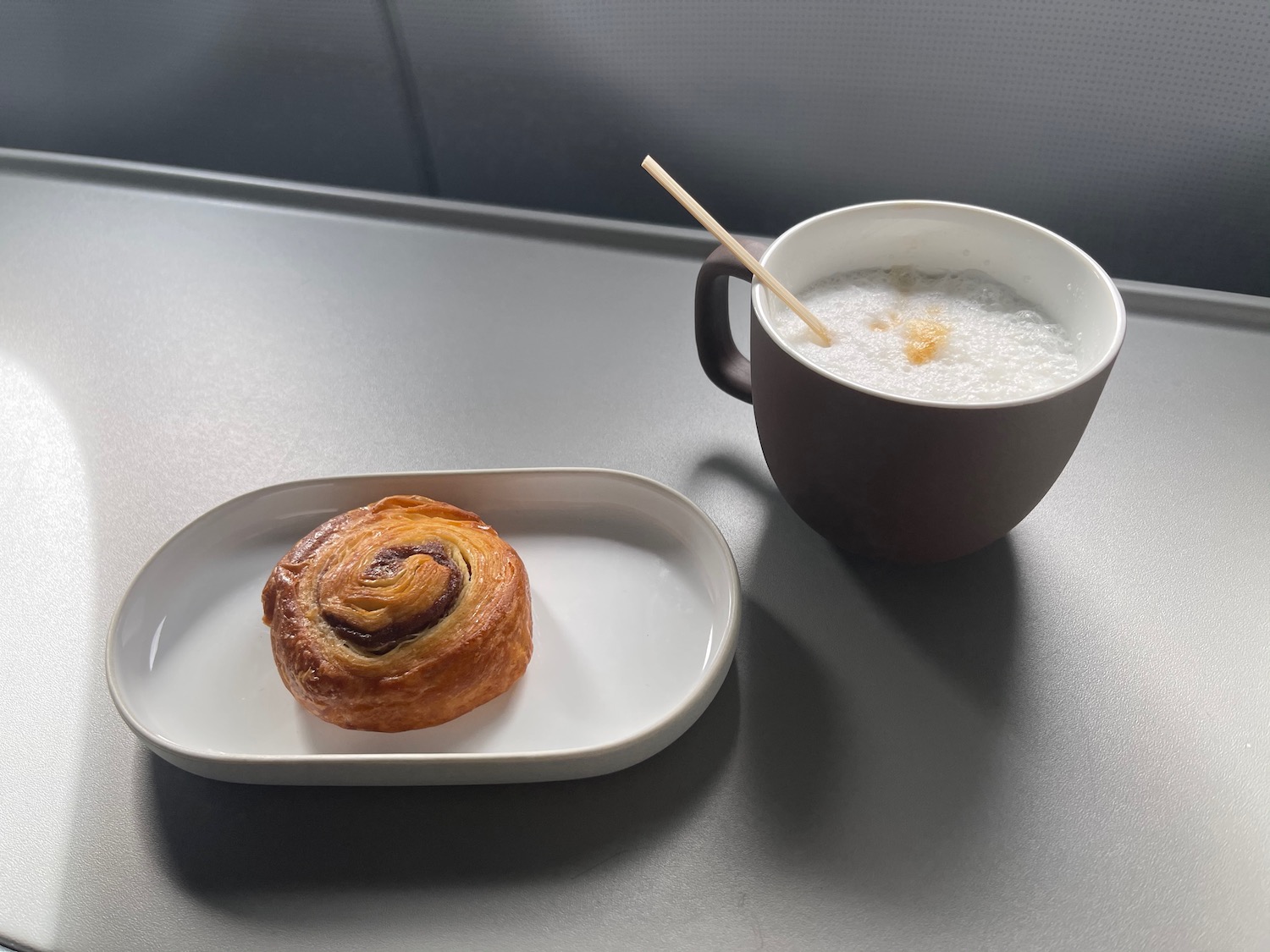 a pastry on a plate next to a cup of coffee