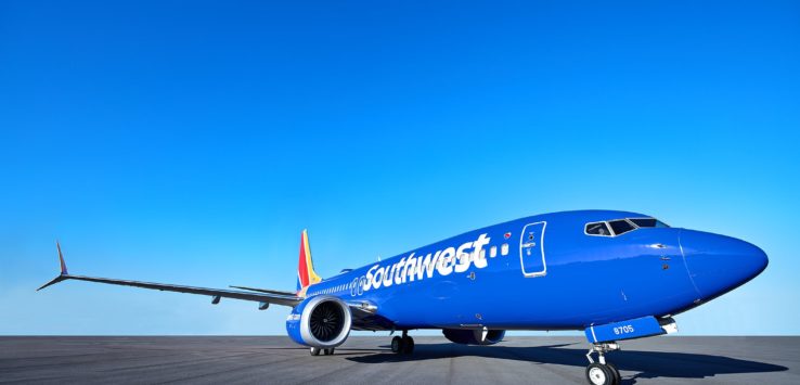 a blue airplane on a runway