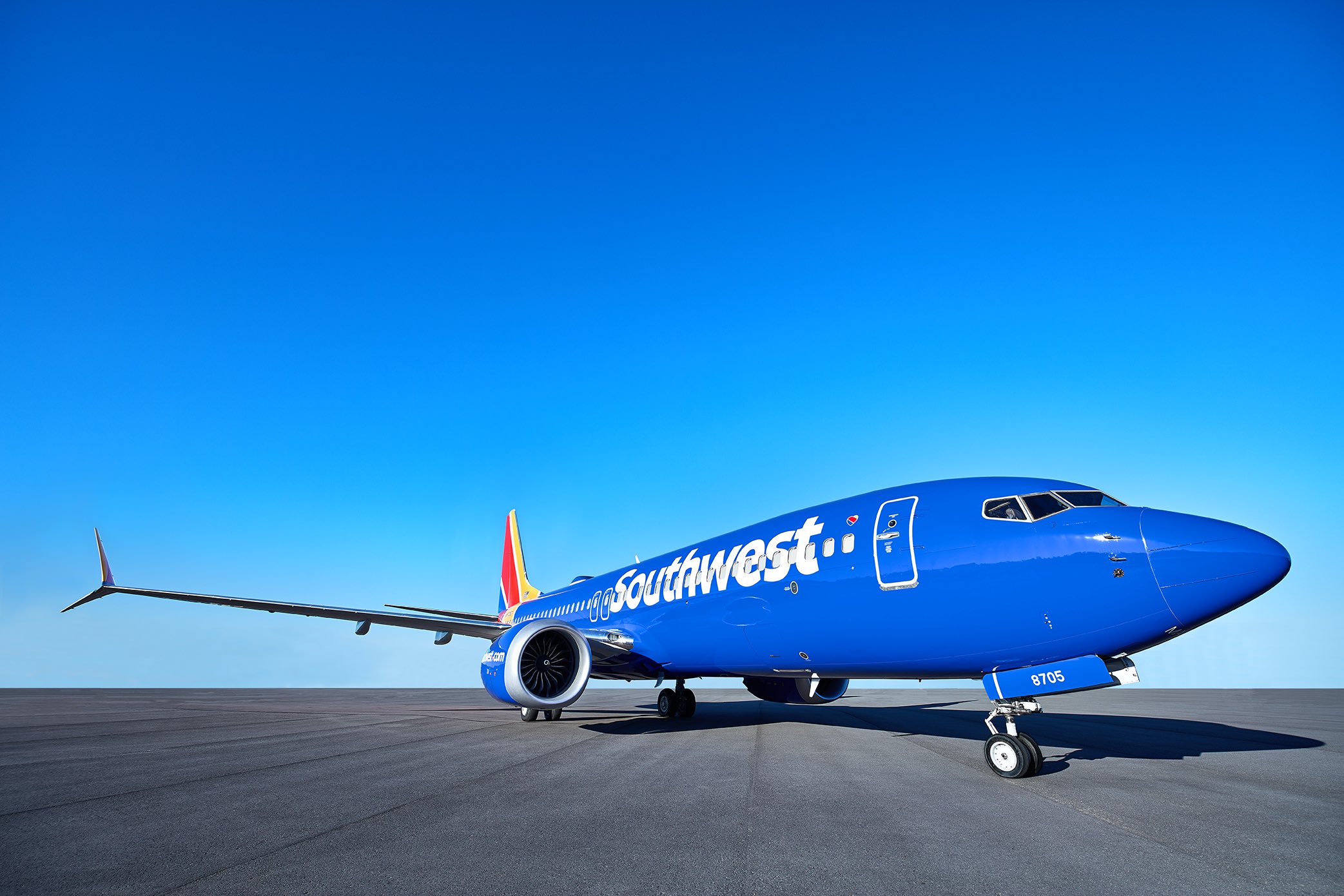 a blue airplane on a runway