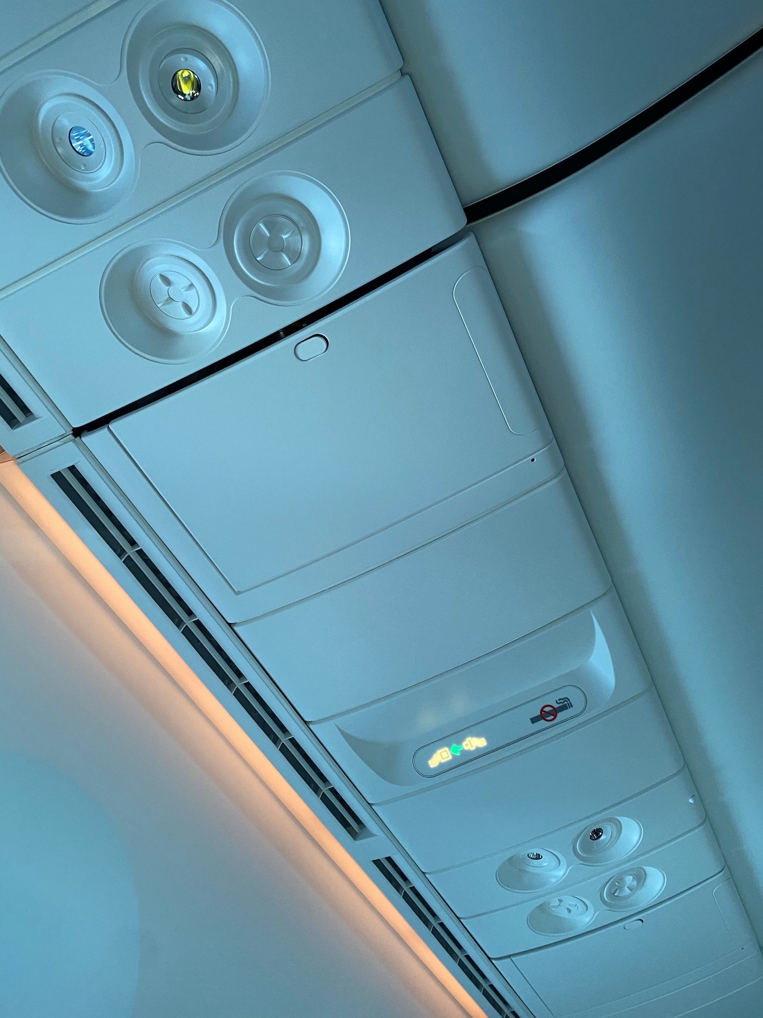 a white airplane seat with lights and buttons