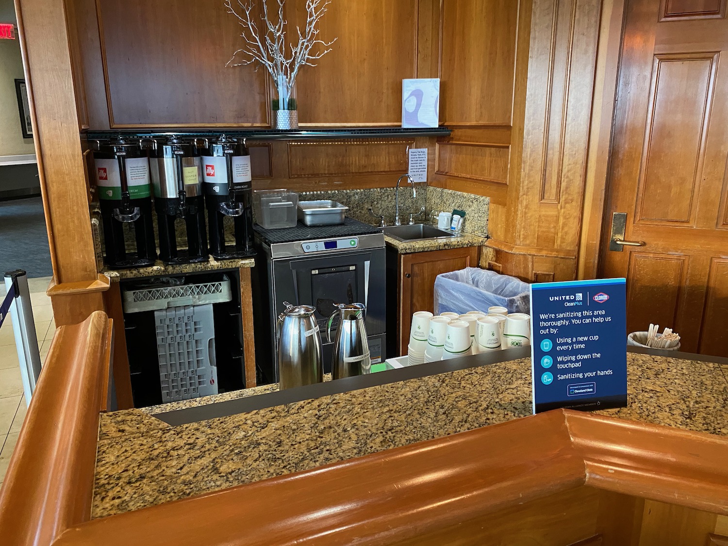 a counter with coffee machines and a sign