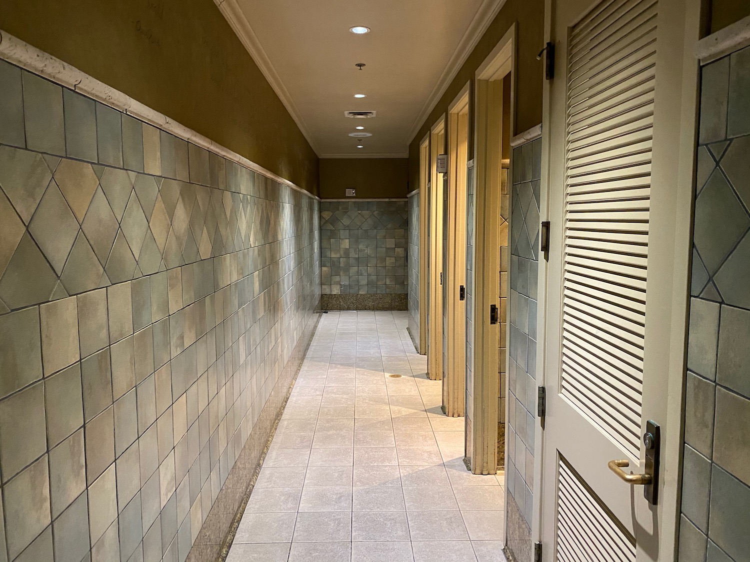 a hallway with doors and tile walls