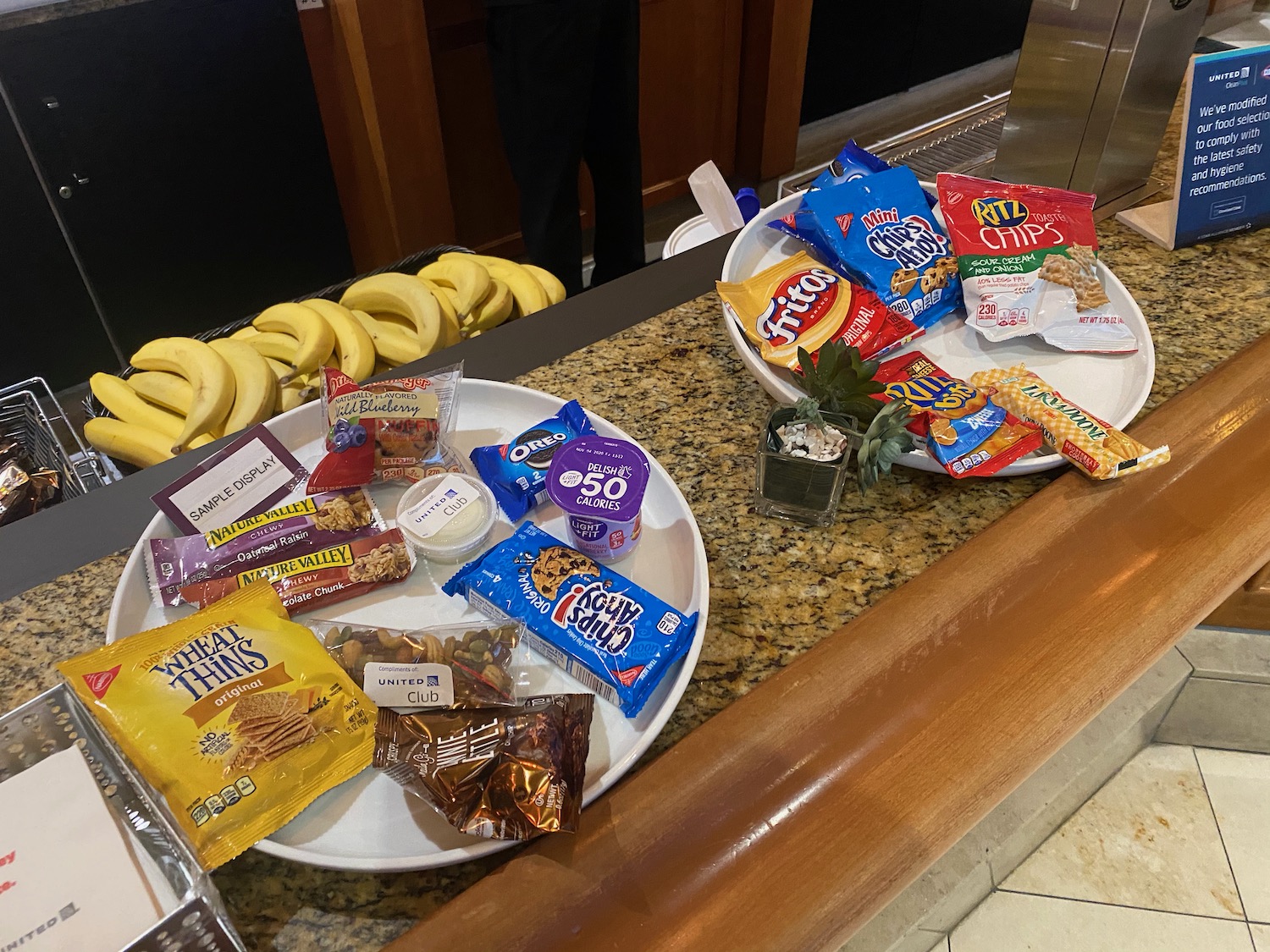 a group of plates of snacks and bananas on a counter