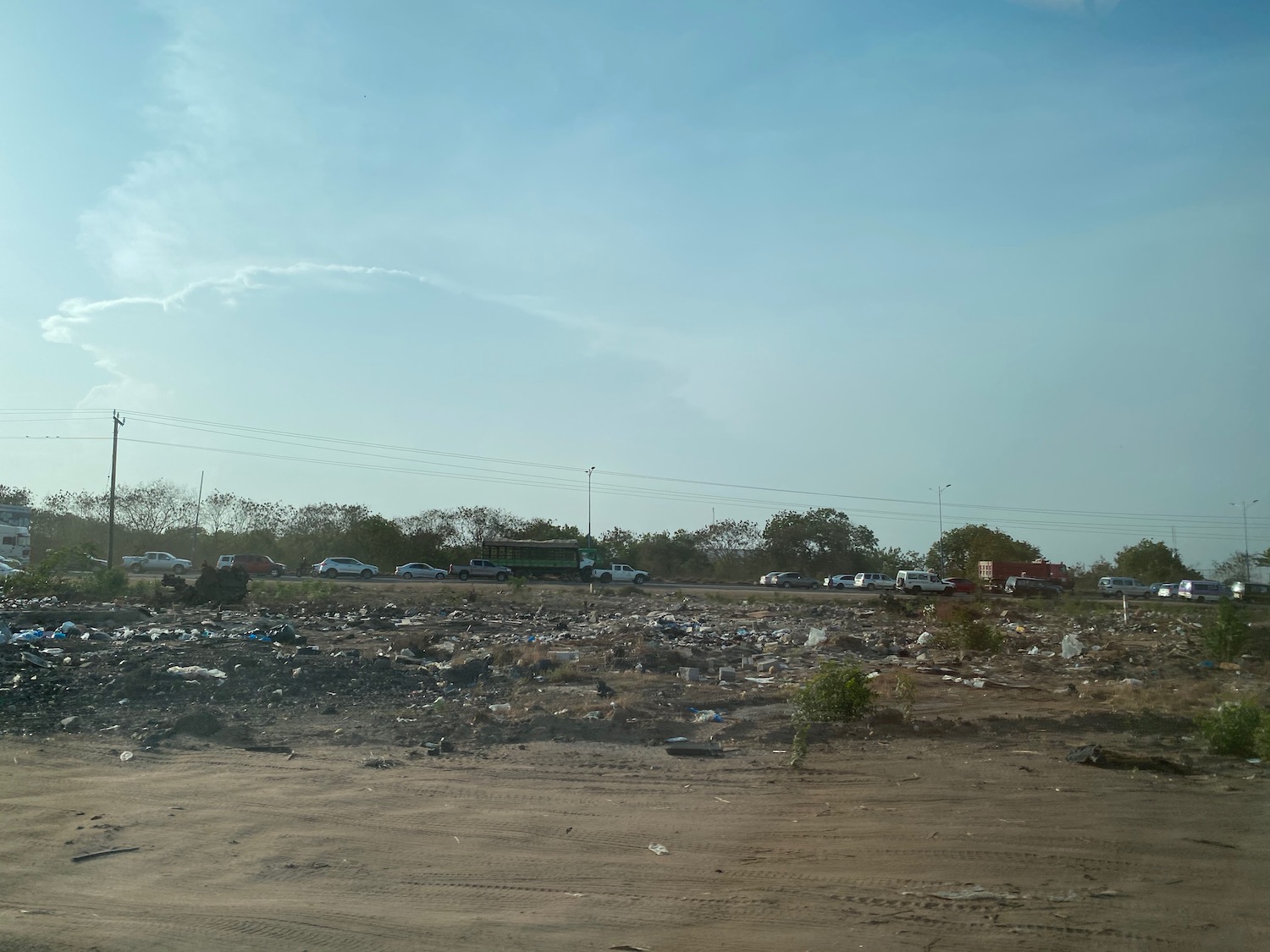 a dirt field with cars and trees