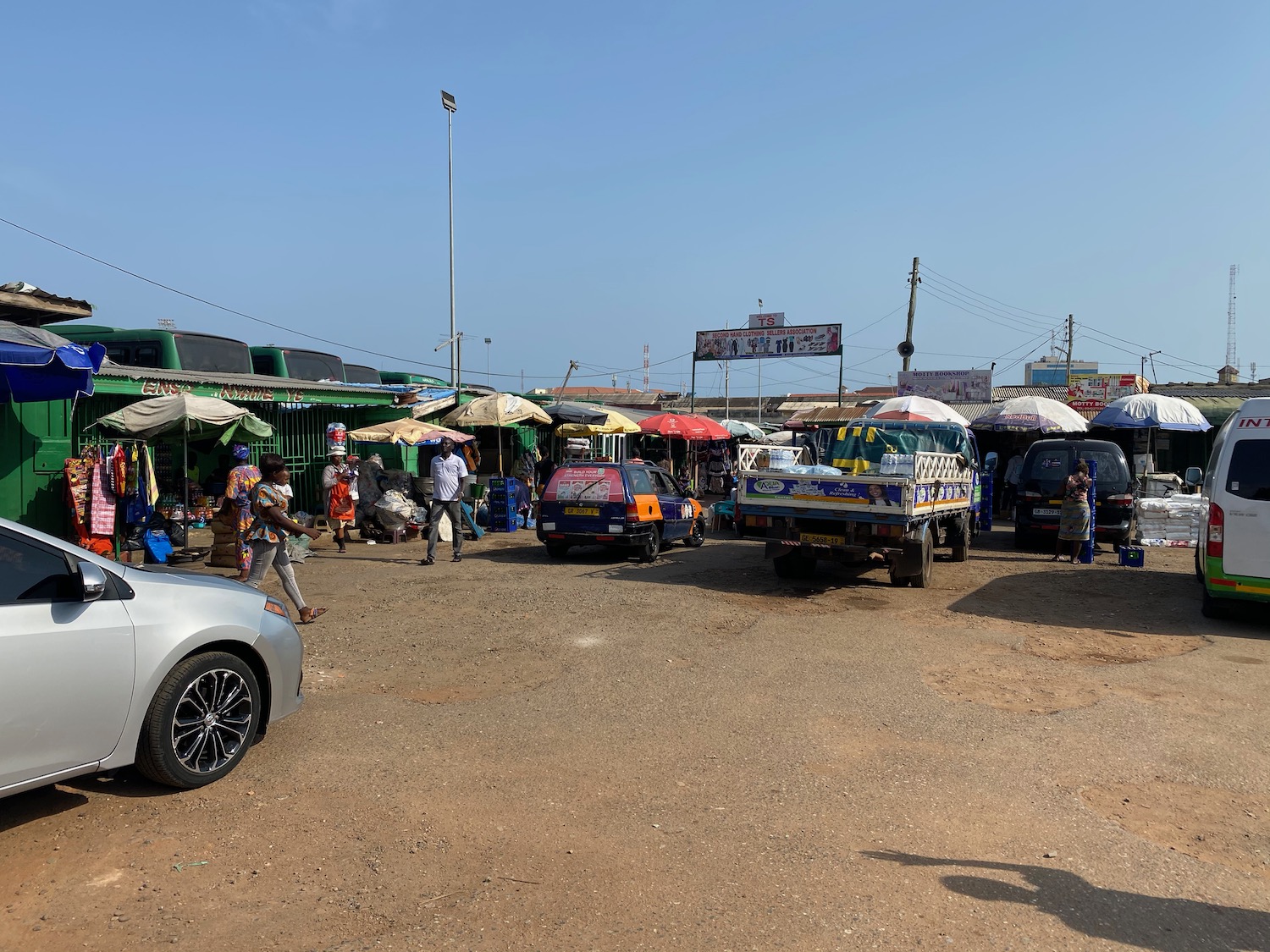 a group of cars and trucks with umbrellas in a parking lot