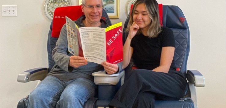 a man and woman sitting in a chair reading a book