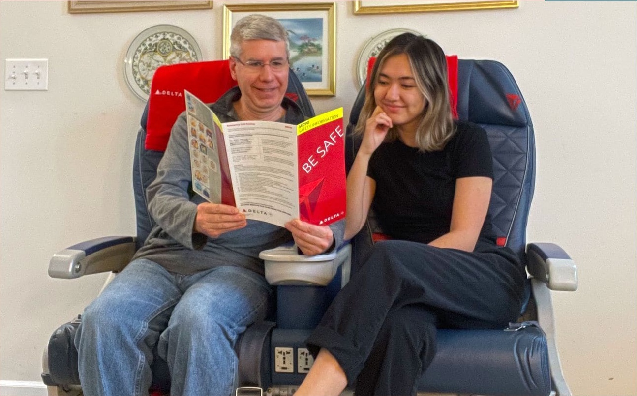 a man and woman sitting in a chair reading a book