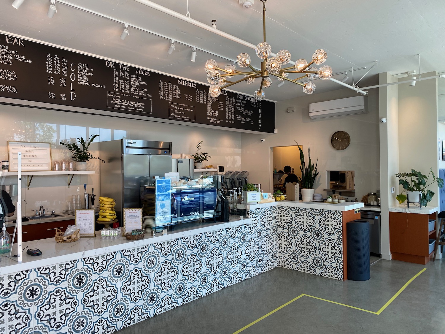 a coffee shop with a large black sign and a large chandelier