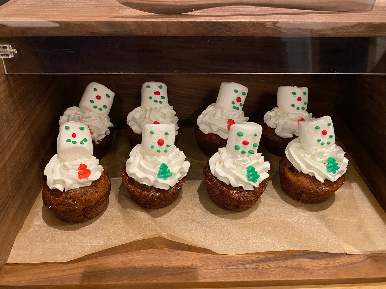 a group of cupcakes with frosting and snowman faces