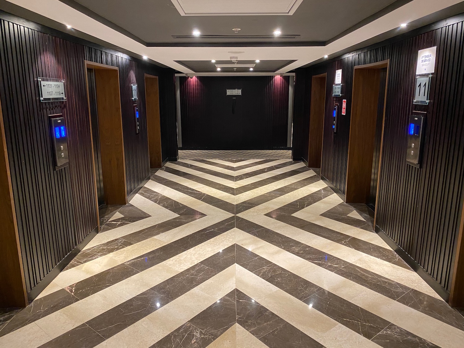 a hallway with doors and a chevron pattern floor