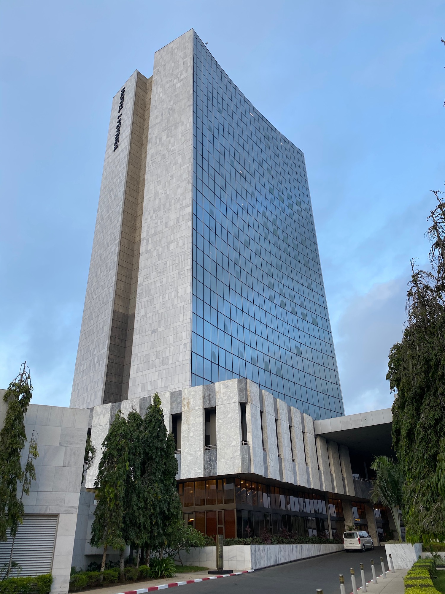 a tall building with trees and blue sky