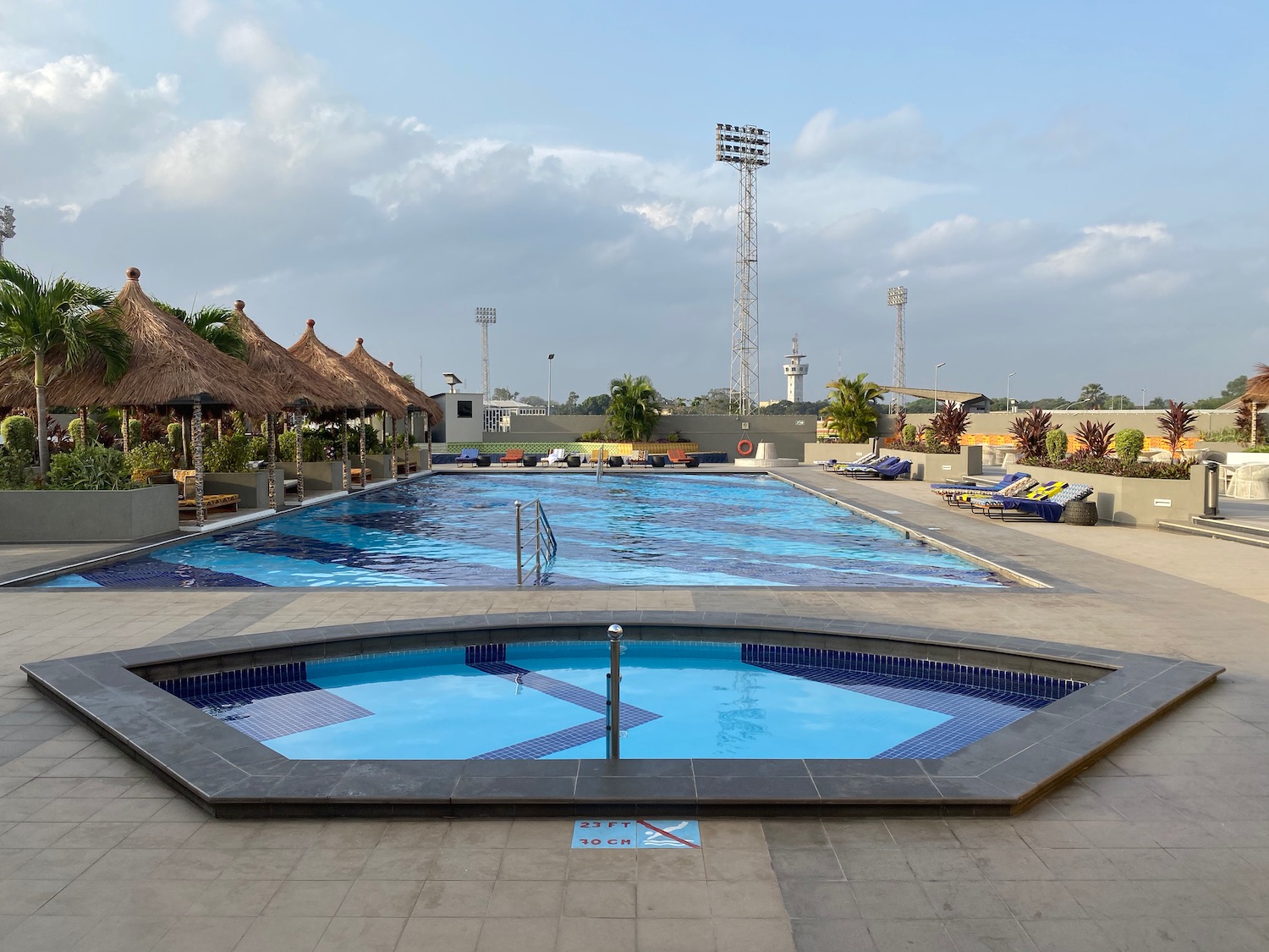 a pool with a large pool and a large building with a roof and a stadium